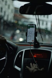 View of a car interior focusing on GPS navigation with raindrops on windshield.